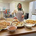 Photo of Nahid with food she's made in a kitchen