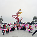 Crowd of people marching with fans and banners.