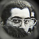 Black and white pixelated portrait of a man wearing glasses framed in a blurred circle