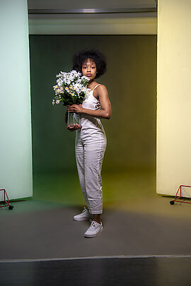woman holding a vase of flowers staring at the camera