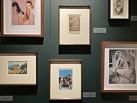 Photographs framed and exhibited on a dark green gallery wall at Photo London 2022.